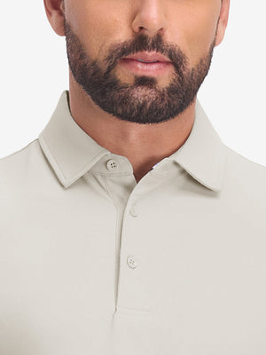 Front shot from nose to chest of model wearing oyster gray dry fit waffle textured collared golf shirts