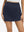 Front lower body shot of model wearing navy high waist built-in short a-line golf skirt with 5 pockets