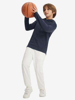 Full-body view of model holding basketball, wearing youth long sleeve hoodied with kangaroo pocket in navy.