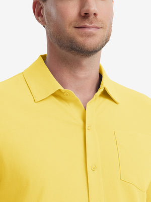 Model front view from nose to chest wearing yellow cotton blend plain shirt.