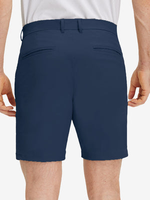 Back lower body shot of model wearing dark blue flat front flex cotton blend golf shorts