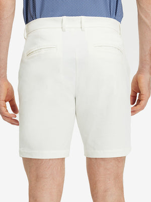 Back lower body shot of model wearing white flat front flex cotton blend golf shorts