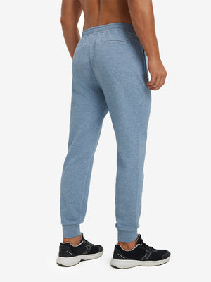 Back lower body view showing blue heather soft sweatpants with 4 zipper pockets