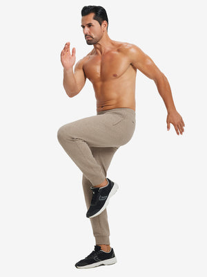 Back lower body view showing light brown heather soft sweatpants with 4 zipper pockets