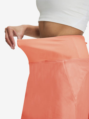 Detail view of elastic waistband on peach pink women's stretch a-line golf skort with 7 pockets