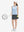 Front full body shot of model playing golf in blue plaid women's sleeveless v-neck print golf shirts