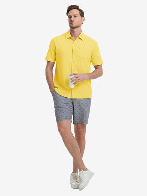 Full-body view of model holding takeaway drink cup in yellow cotton blend plain shirt.