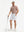 Full-body shot of model holding a golf club in brick white flower performance quick dry print golf polos