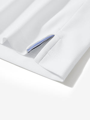 Detail view of hem on white dry fit waffle textured collared golf shirts
