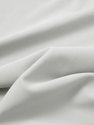 Close-up texture of silver grey waffle texture 1/4 zip pullover fabric showing detailed waffle knit material and weave.