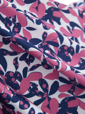 Close-up texture of rose red florals women's sleeveless v-neck print golf shirts fabric showing printed weave detail.