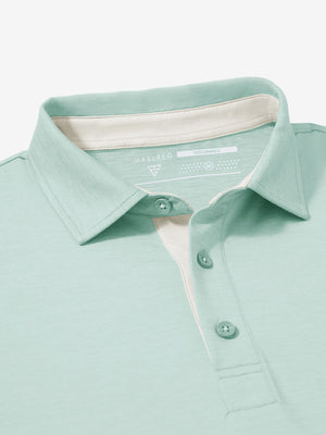 Collar and button detail close-up in light green heather of performance heather contrast collar polo shirts.