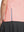 Detail view of hem design on coral powder women's breathable 1/4 zip pullover golf shirts