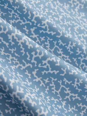 Close-up texture of white blue abstract stylish full print contrast collared golf polo shirts fabric showing weave detail.