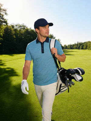 Model with golf bag on outdoor course wearing aqua blue upgraded two-tone striped quick dry polo shirt
